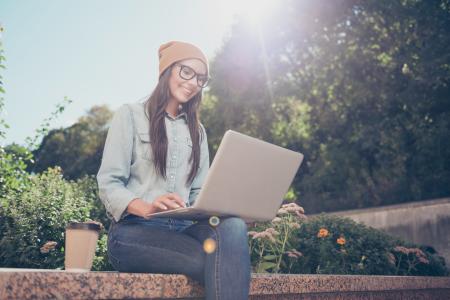 Smiling student using Splashtop on laptop outdoors