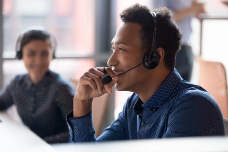 IT pro providing remote support while co-worker looks on